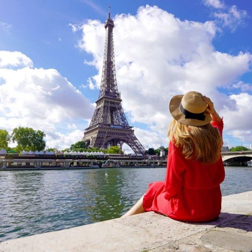 young-traveler-woman-red-dress-hat-sitting-quay-seine-river-looking-eiffel-tower-famous-landmark-travel-destination-paris